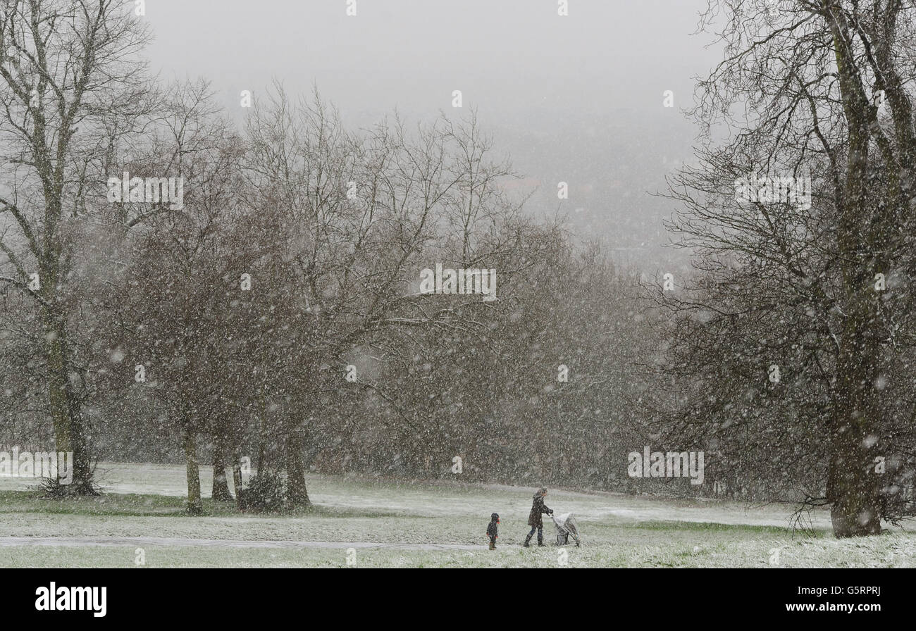 Woman young boy walk during snowfall near alexandra palace hires stock
