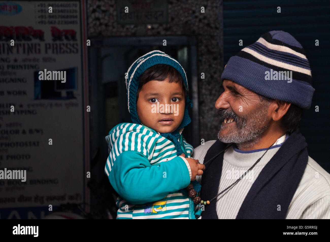 Unidentified Indian grandfather with his granddaughter on the street in Agra Stock Photo