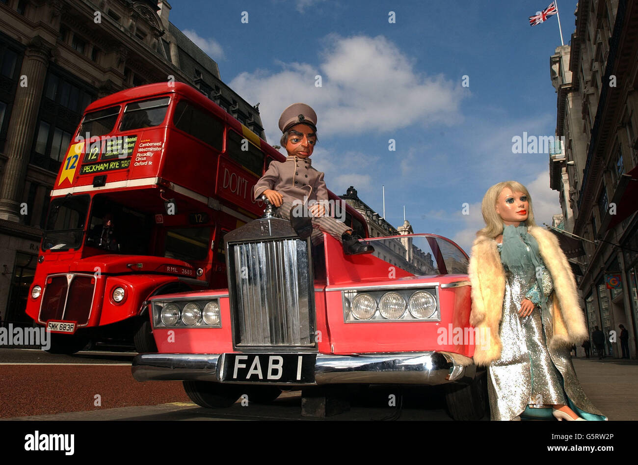 Lady Penelope and her butler Parker, from Thunderbirds, with the FAB 1 car on Regent Street, 37 years after they climbed into the their pink roadster. The original items are to be sold at auction at Planet Hollywood, London. Stock Photo