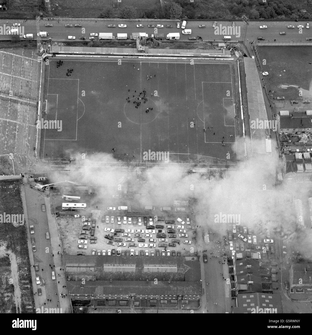 Aerial view of Bradford City's Valley Parade football ground with smoke rising from the devastating fire, which swept the main stand in four minutes just before half-time during the Division Three match against Lincoln City in the last game of the season. 56 people died and 265 were injured. Stock Photo