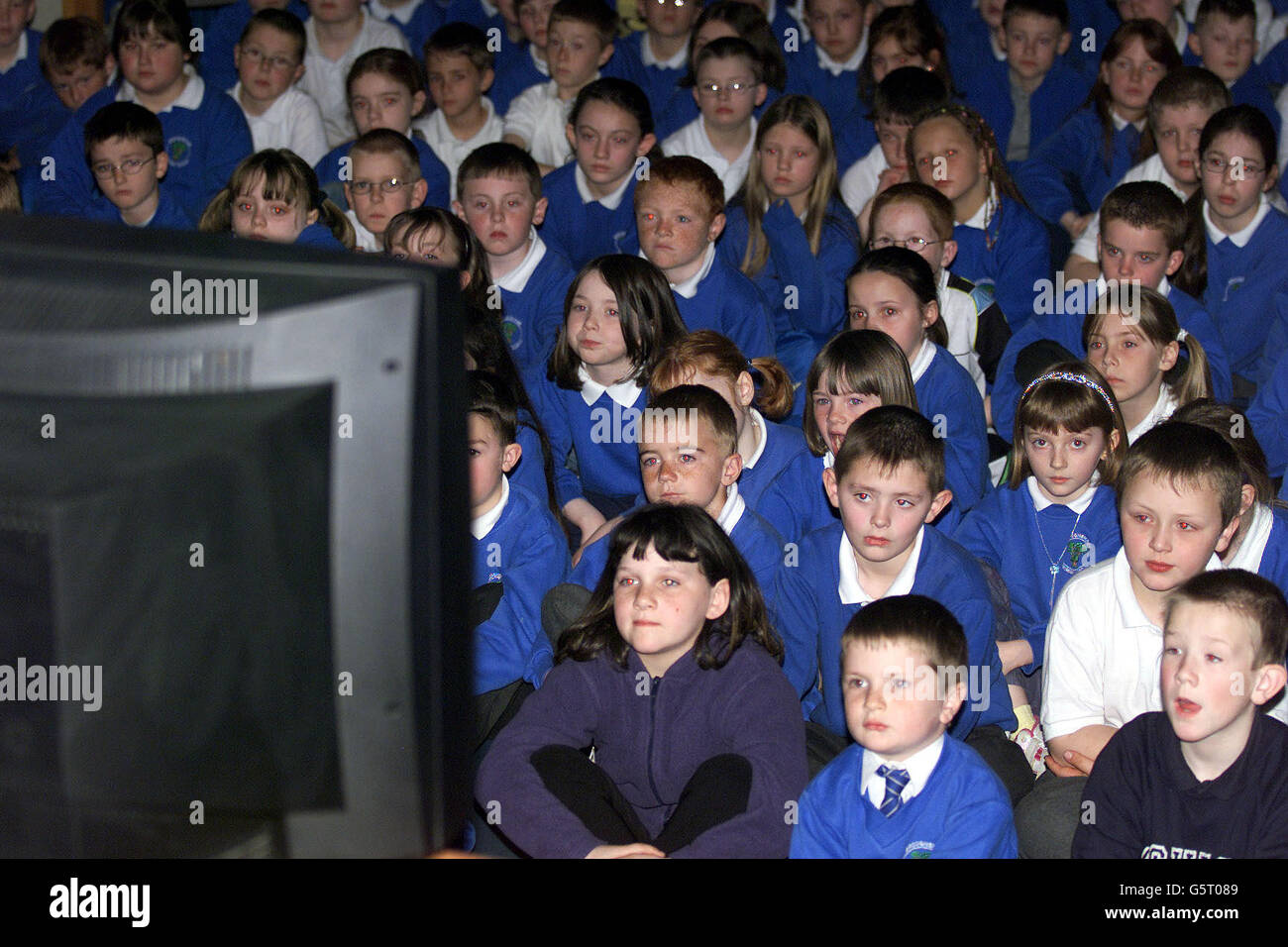 Children from Broughshane Primary school in Northern Ireland watch the Queen Mother's funeral on television . Stock Photo