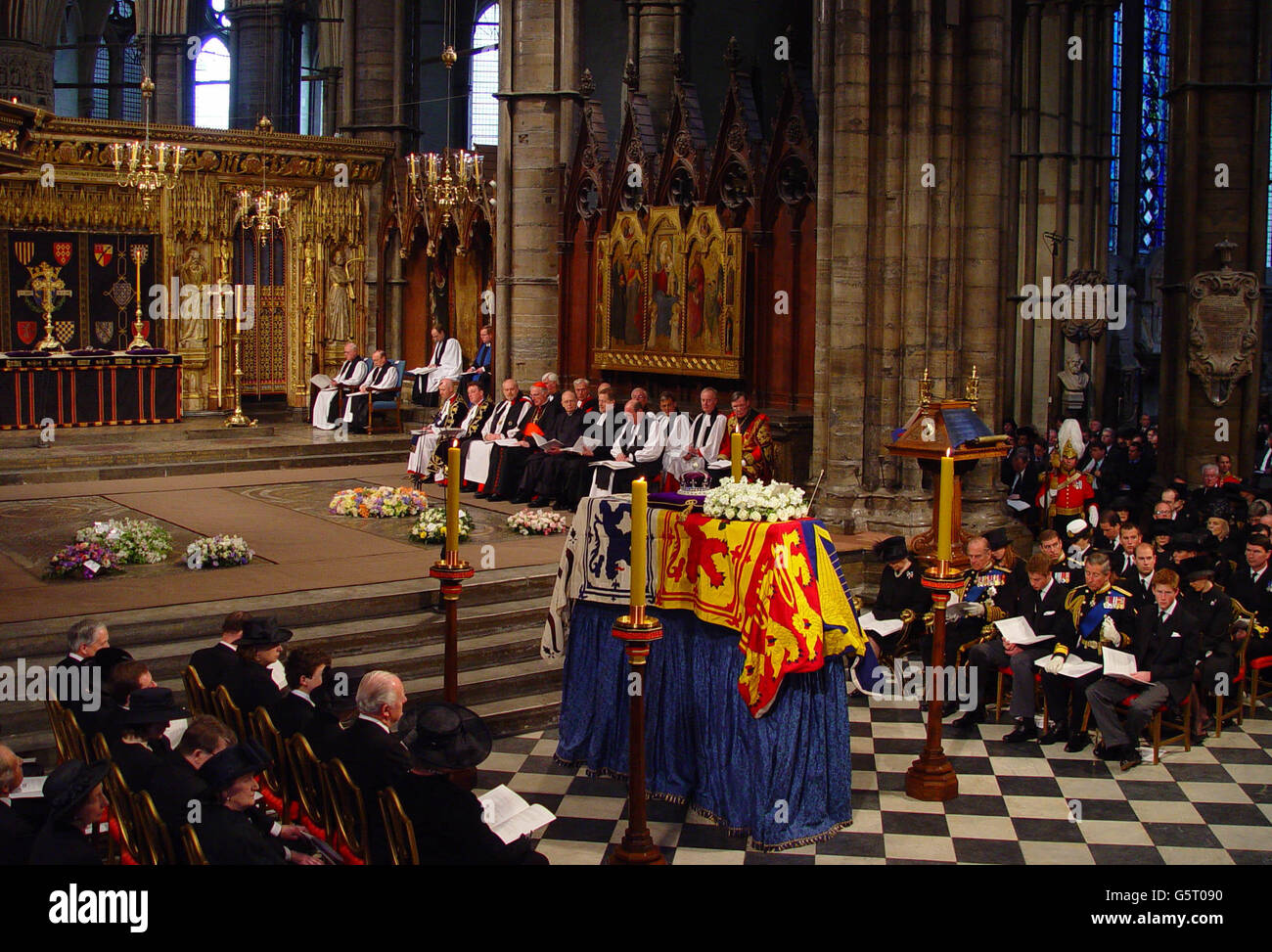 Members of the British Royal family sit in front of the coffin in