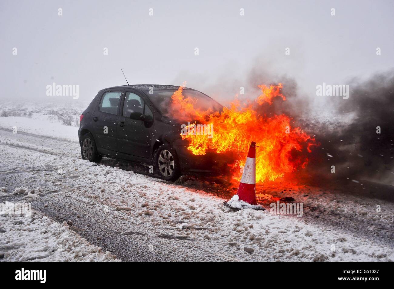 A car fire on a hill on the B3212 at Dartmoor, Devon, after its driver Matthew Shipton 21, from Callington, was driving home from his workplace at Bovey Castle after they let him finish four hours early due to the bad weather conditions. Stock Photo