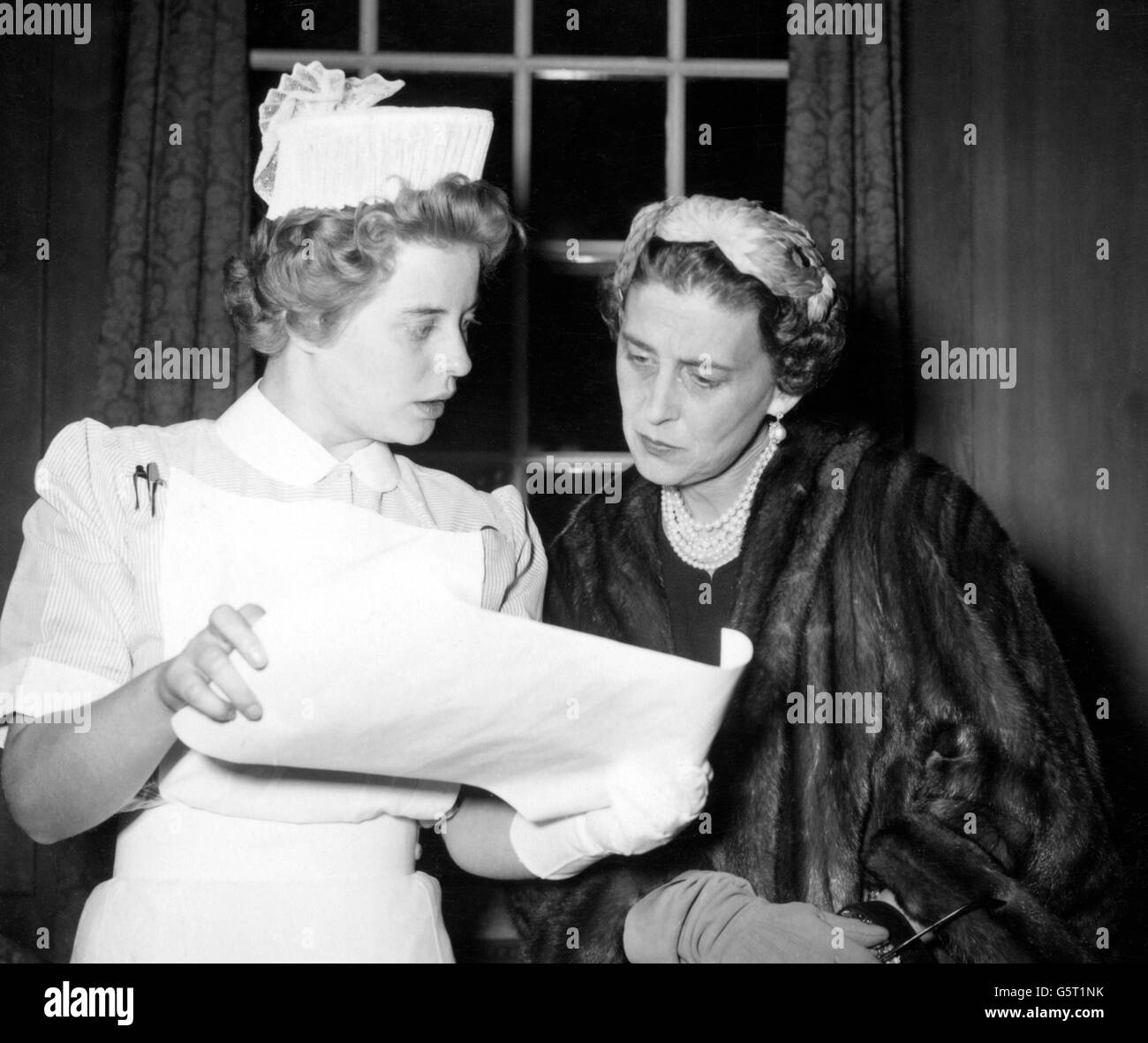 The Duchess of Kent reads the Nightingale Training School certificate proudly shown by her cousin, Princess Margarita of Baden - a student nurse - at St Thomas's Hospital, Lambeth in London. The Princess, who has been studying nursing in Britain for the past two years, was one of many student nurses who received certificates and medals from the Duchess during today's presentation. Stock Photo