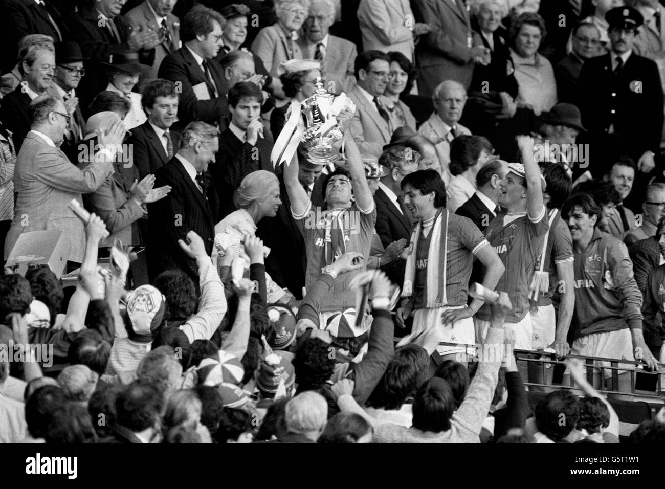 Kevin Ratcliffe, at 23 the youngest FA Cup winning captain for 20 years, holds the trophy aloft after Everton's 2-0 victory over Watford. The Duchess of Kent, who presented the Trophy is left and goalscorers Graeme Sharp and Andy Gray (with hat) are behind their skipper. Stock Photo