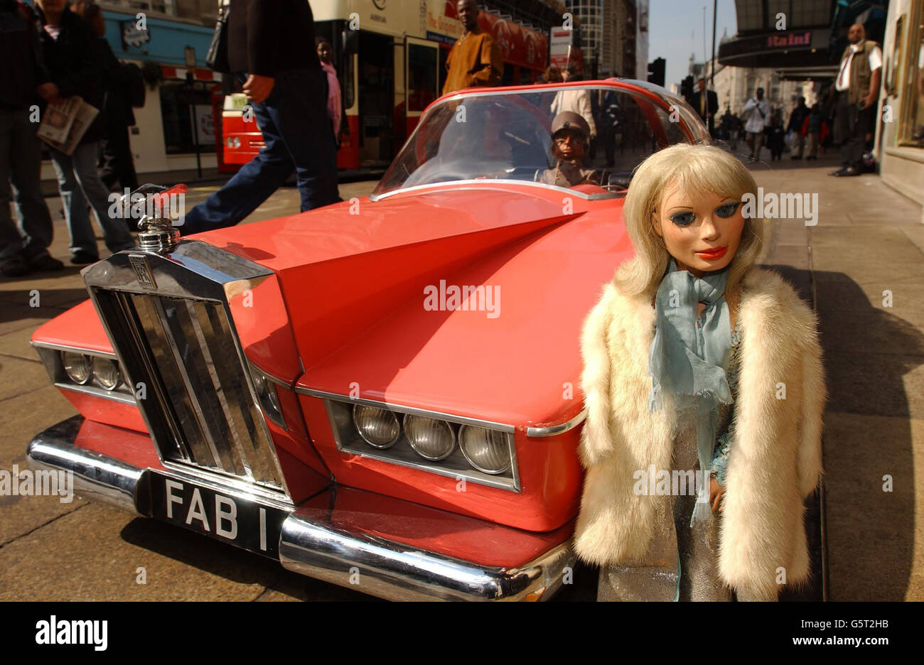 Thunderbirds puppets Lady Penelope and Parker with her pink Rolls Royce outside Planet Hollywood, central London. The puppets are part of the 'At The Movies' film and entertainment auction. The Lady Penelope puppet is expected to fetch at least 20,000. *... and Parker and FAB1 15,000 each. Stock Photo