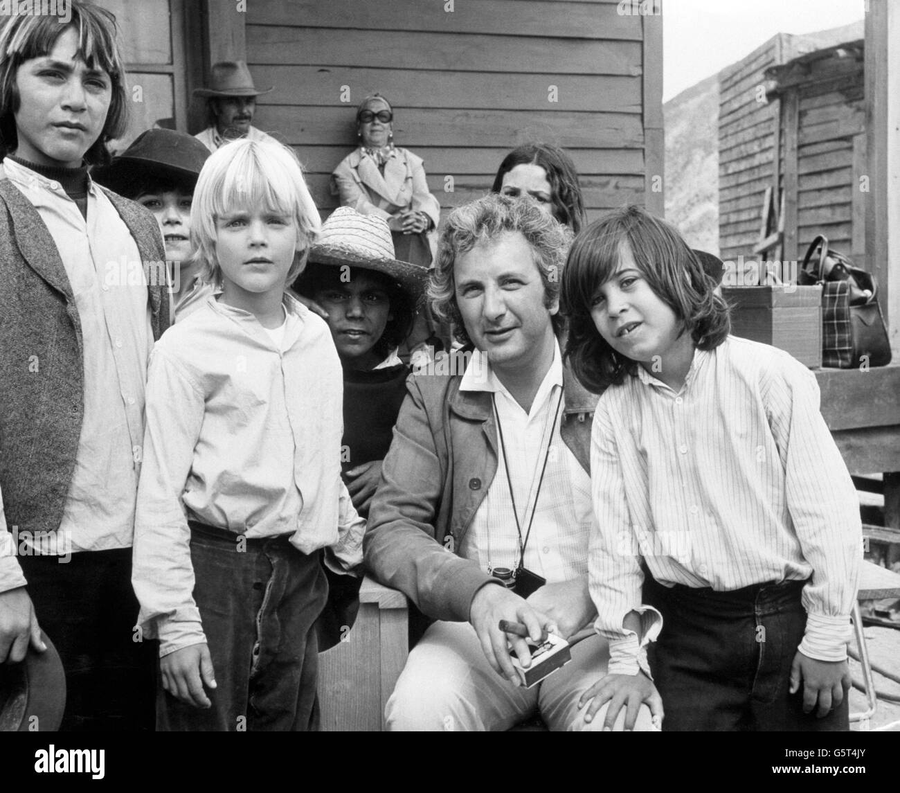 Film director Michael Winner on the set of his western Chato's Land, which stars Charles Bronson. Two of the young actors with him, Jason (right) and Valentine (blond, centre), are sons of British actors Jill Ireland and David McCallum. Stock Photo