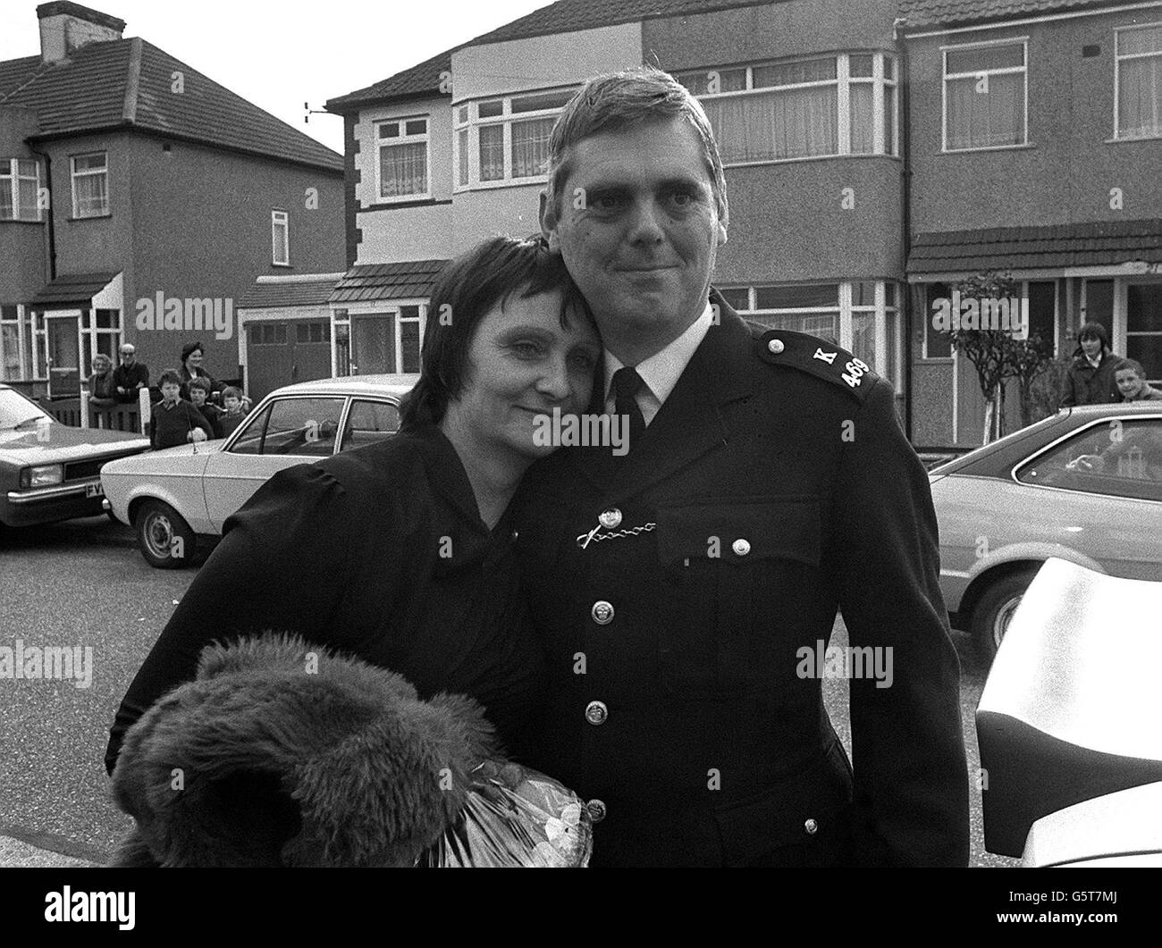Neighbours and children look out from their homes in Warley Road, Dagenham, as Police Constable Trevor Lock returns home with his wife, Doreen, after his six day ordeal in the Iranian embassy siege. Stock Photo