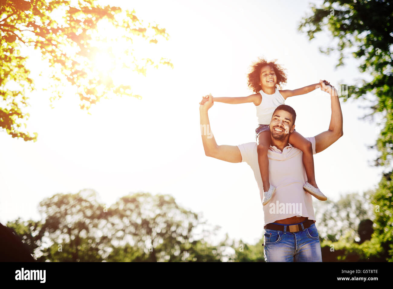Father carrying daughter piggyback and being truly happy Stock Photo