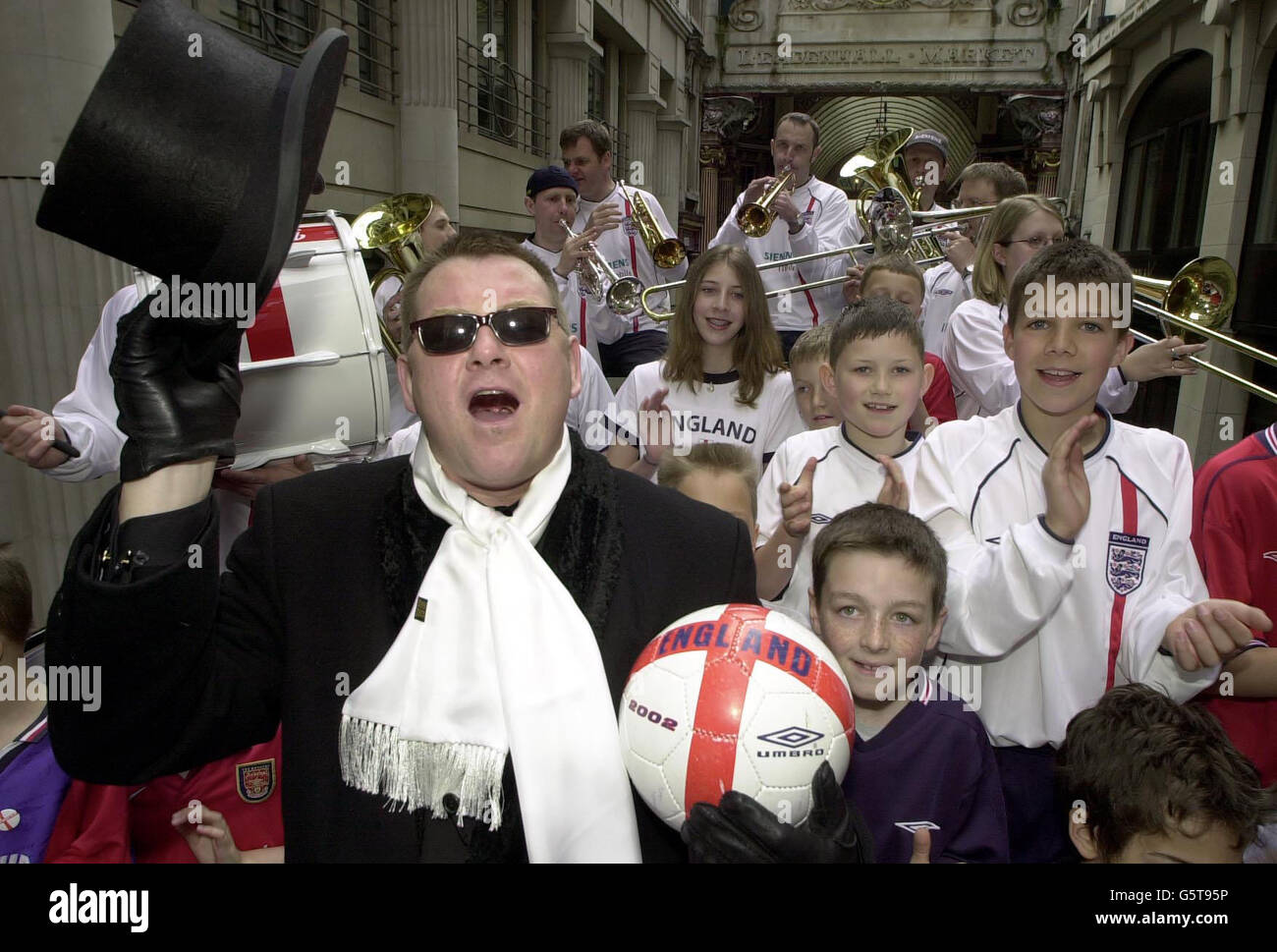 Chas Smash (left) formerly of the pop group Madness, with the England brass band and young football fans in the city of London, to make the video to his World Cup anthem 'We're coming over' which will be released on the 27th May. * The song is one of a number that are being released in the run up to the World Cup in Japan and South Korea this Summer. Stock Photo