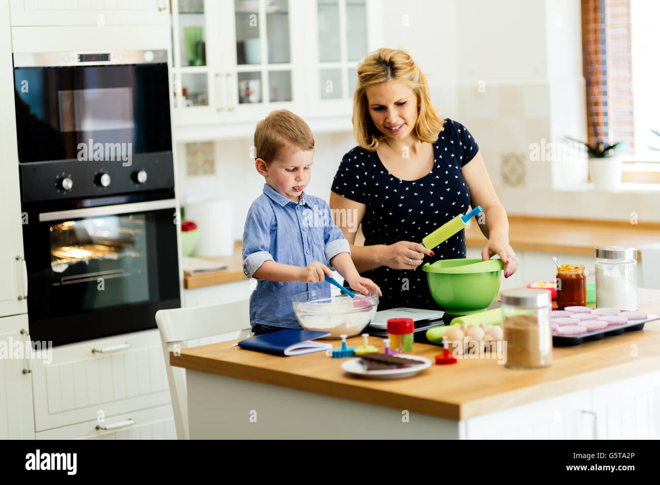 Child Helping In Kitchen Child helping mother make cookies in modern kitchen Stock Photo - Alamy