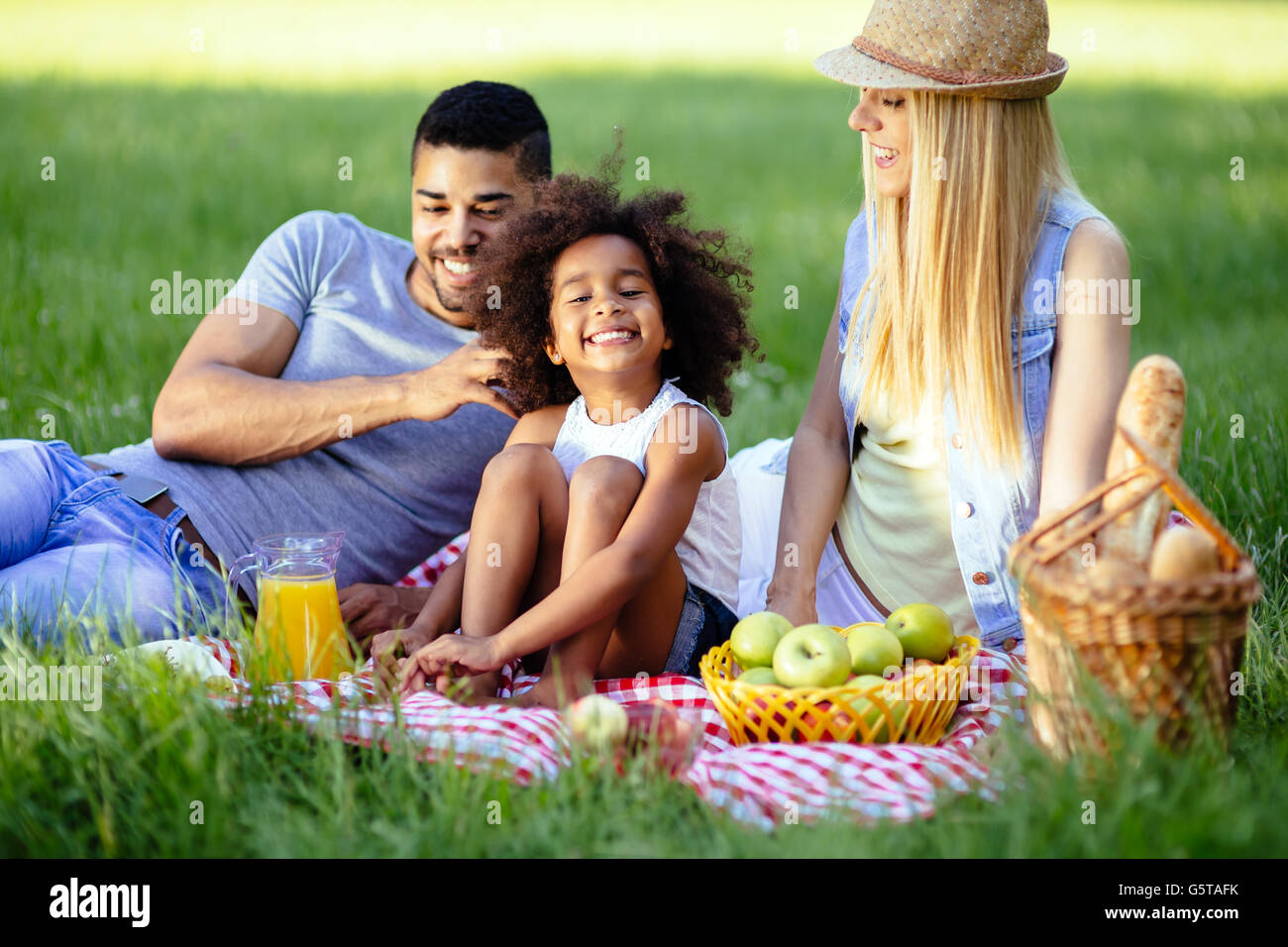 Family picnicking outdoors with their cute daughter Stock Photo