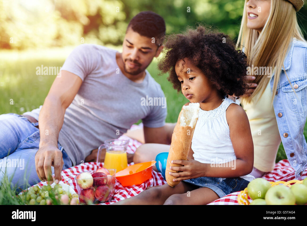 Beautiful afro kid holding baguette while picnicking Stock Photo