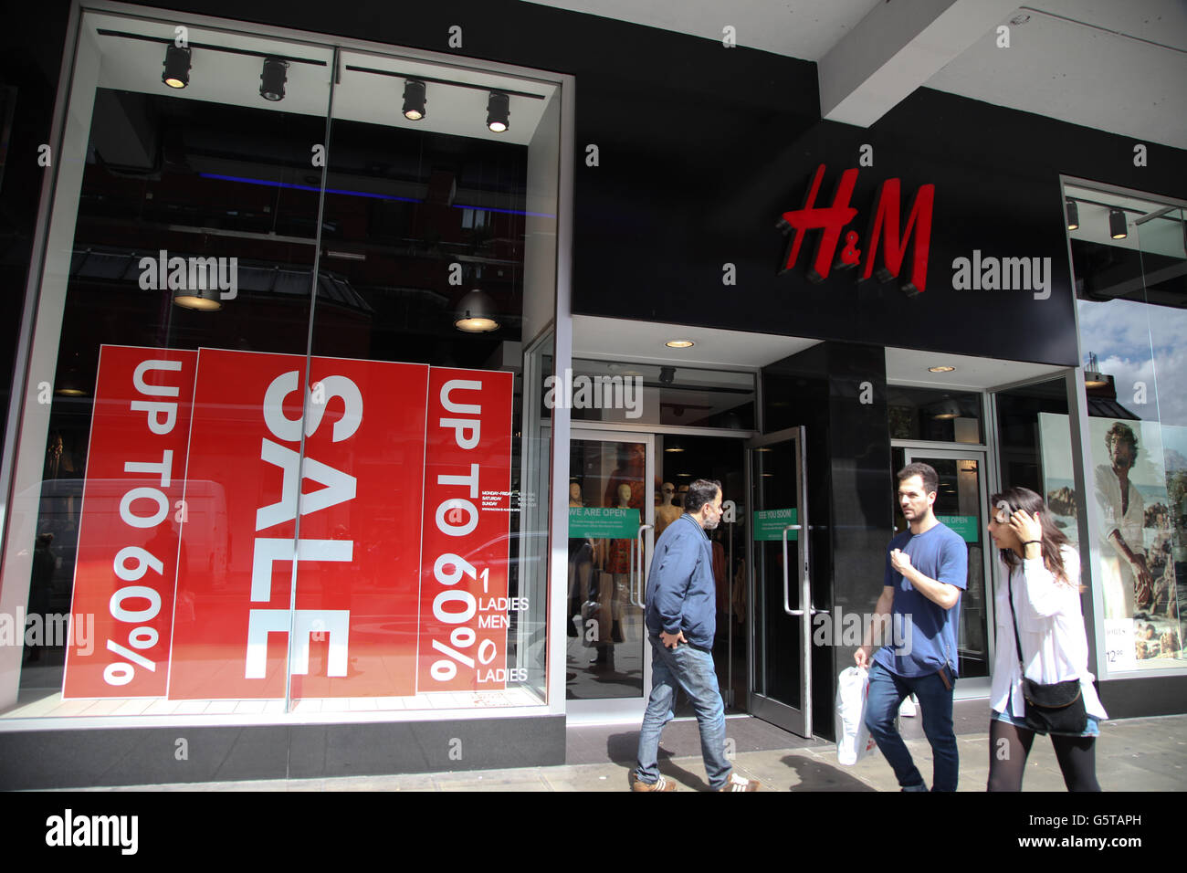 Shoppers walks past the sale sign in H&M store in Wood Green, North London  Stock Photo - Alamy