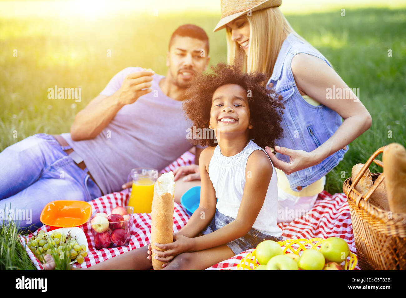 Family picnicking outdoors with their cute daughter Stock Photo