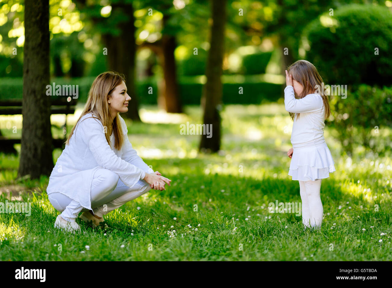 Mother scolding child and she covers face feeling ashamed Stock Photo