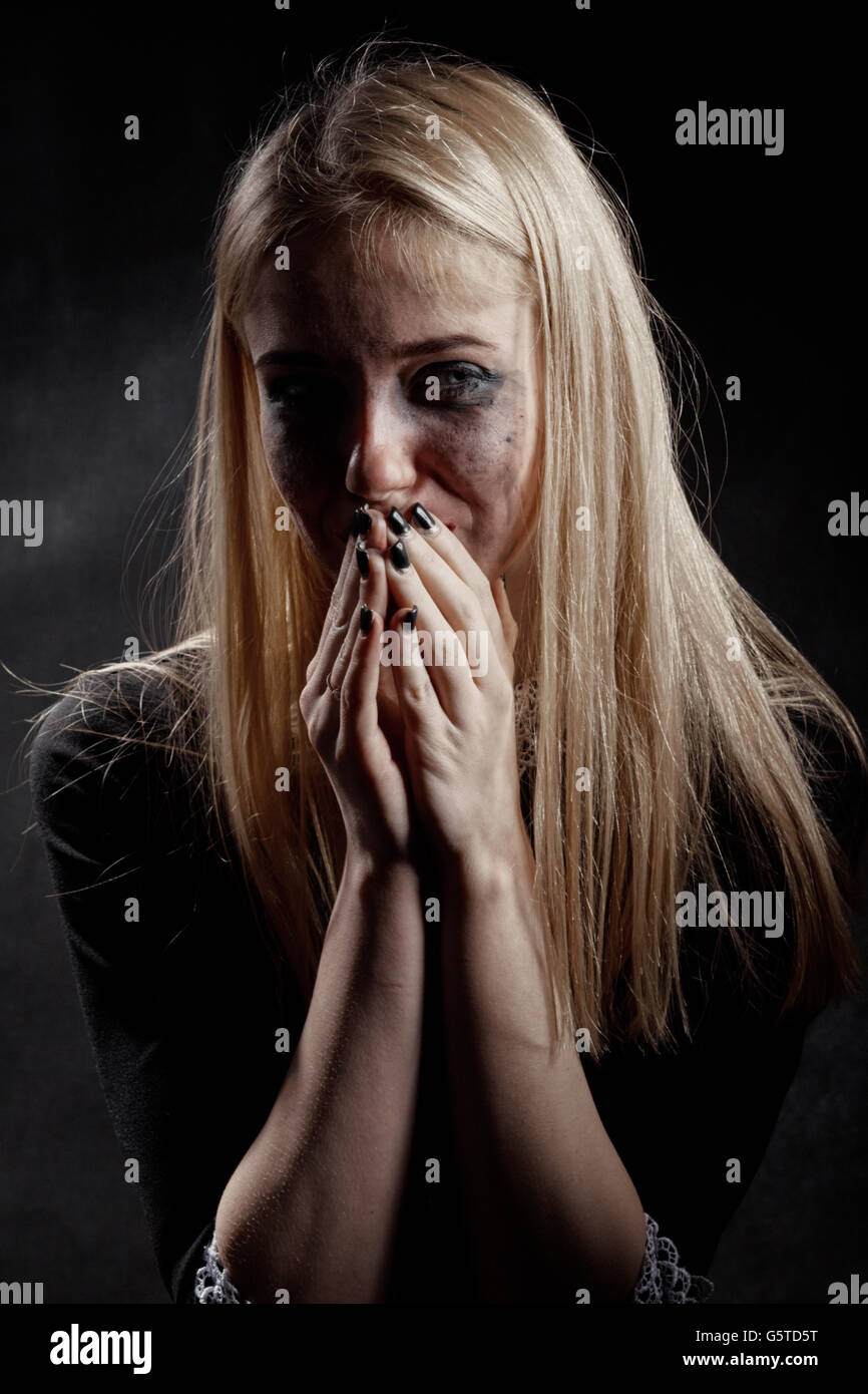 woman with smeared cosmetics crying on black background Stock Photo