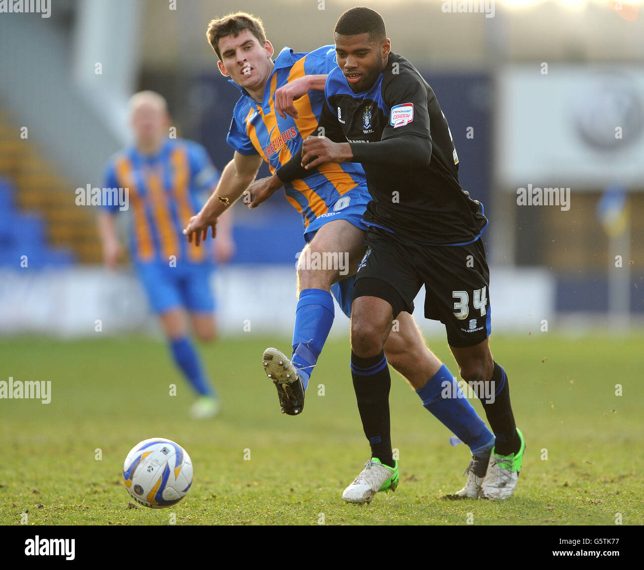 Shrewsbury Town's David McAllister (left) and Bury's Ethan Ebanks-Lander (right) battle for the ball during the npower Football League One match at Greenhous Meadow, Shrewsbury. Stock Photo