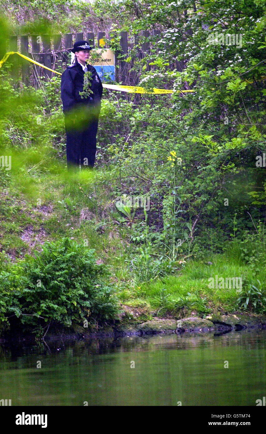 A woman police officer stands on the bank of the River Thames at Sunbury Lock in Surrey near to where a woman's body was found last night. *Surrey Police announced that the body was not that of missing teenager Amanda Dowler, also known as Milly, who went missing on March 21. Stock Photo