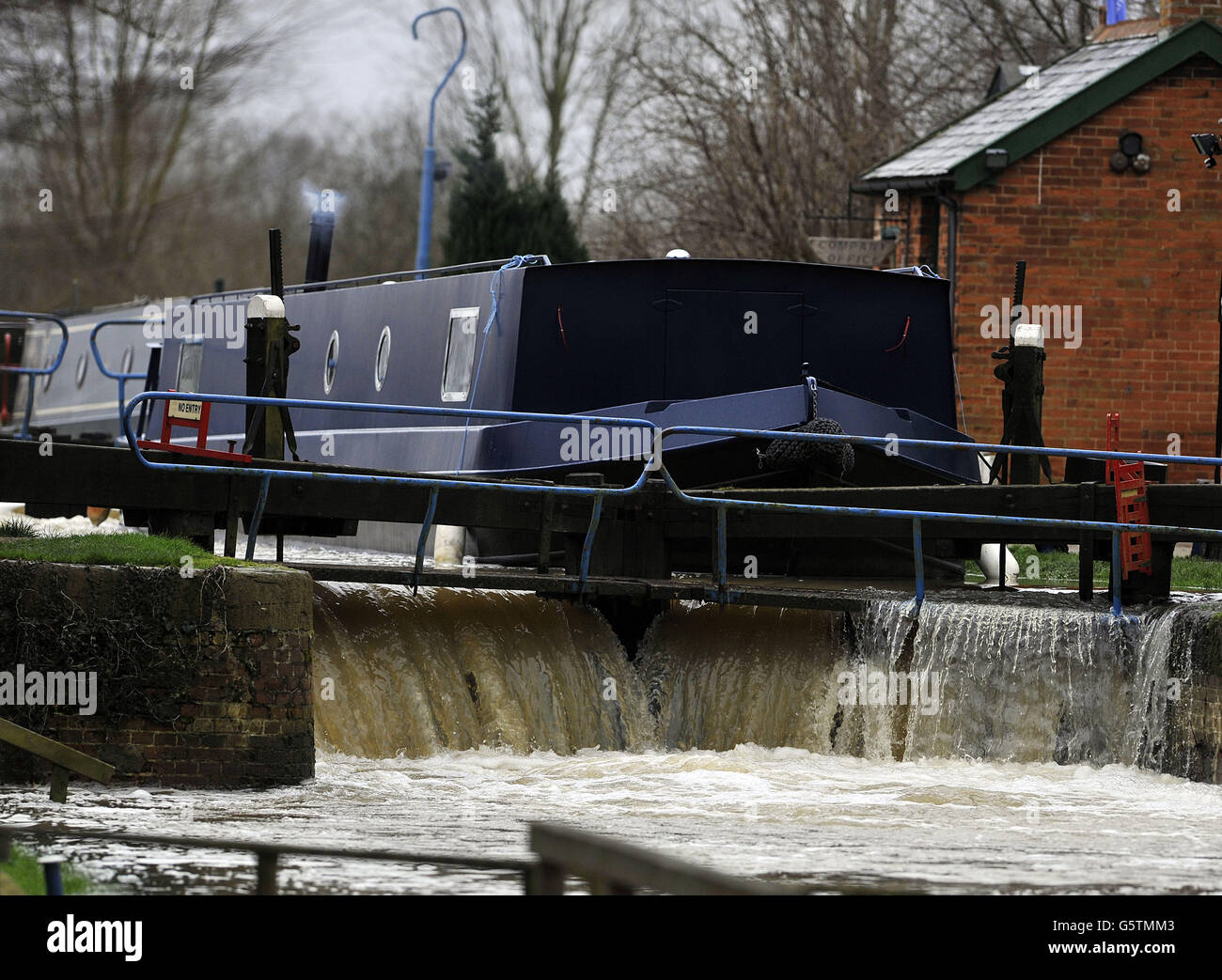 Flood water from recent snow melt bursts over the lock gates of the River Chelmer at Paper Mill Lock, Little Baddow, Essex. Stock Photo