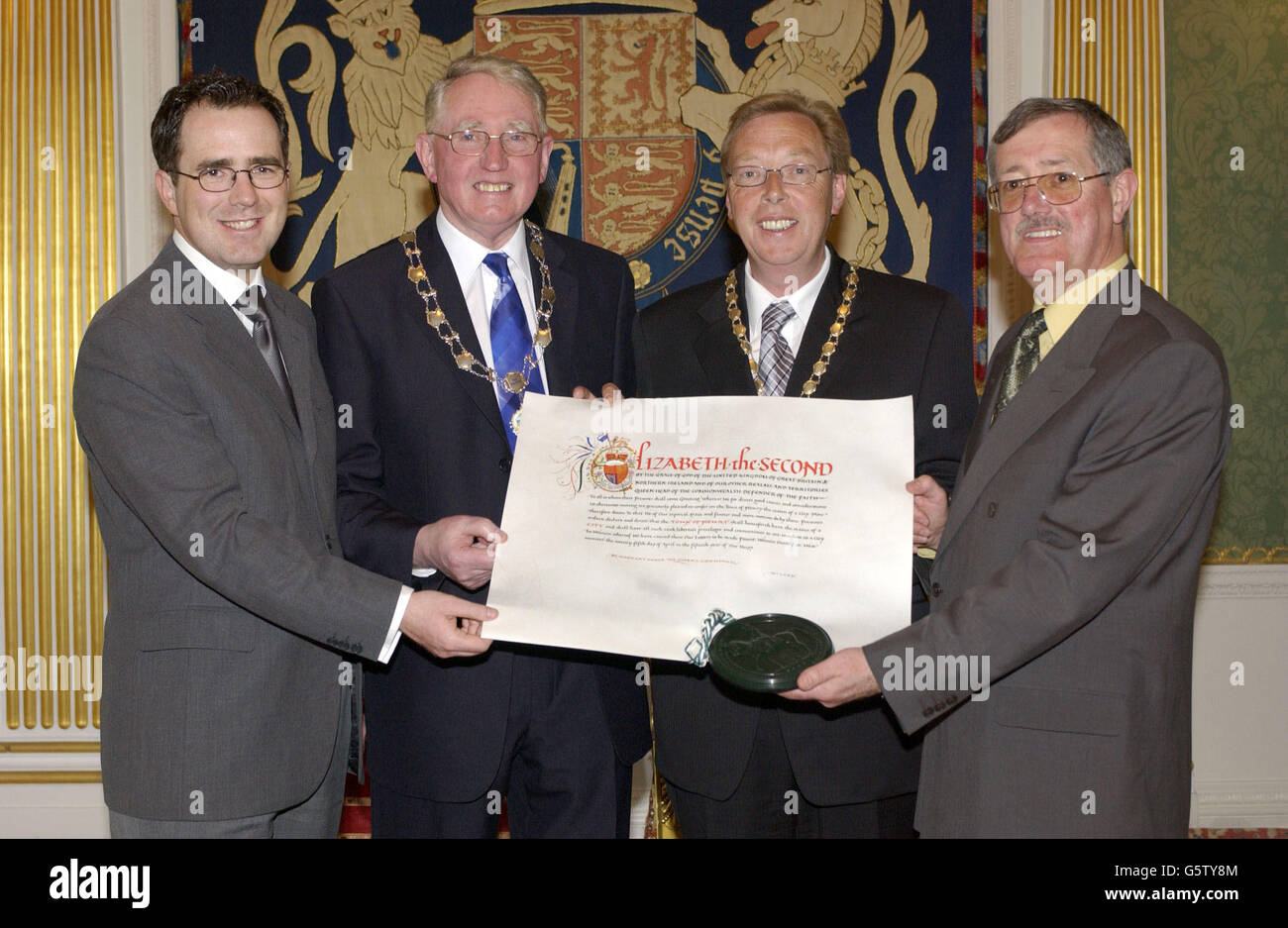 Newry dignitaries hold the Letters Patent endorsed by the Great Seal confering city status on Newry, Northern Ireland presented to the Vice-Chairman of Newry Council, * SDLP Councillor Frank Feely (second left) by Queen Elizabeth II in a ceremony at Hillsborough Castle during the second day of the Monarch's Golden Jubilee visit to Northern Ireland. With the Vice-Councillor are, from left, Newry City Centre Manager Barry Owens, Feely, President of Newry Chamber of Commerce and Trade Gerard O'Hare, and Chief Executive of Newry District Council Tom McCall. Stock Photo