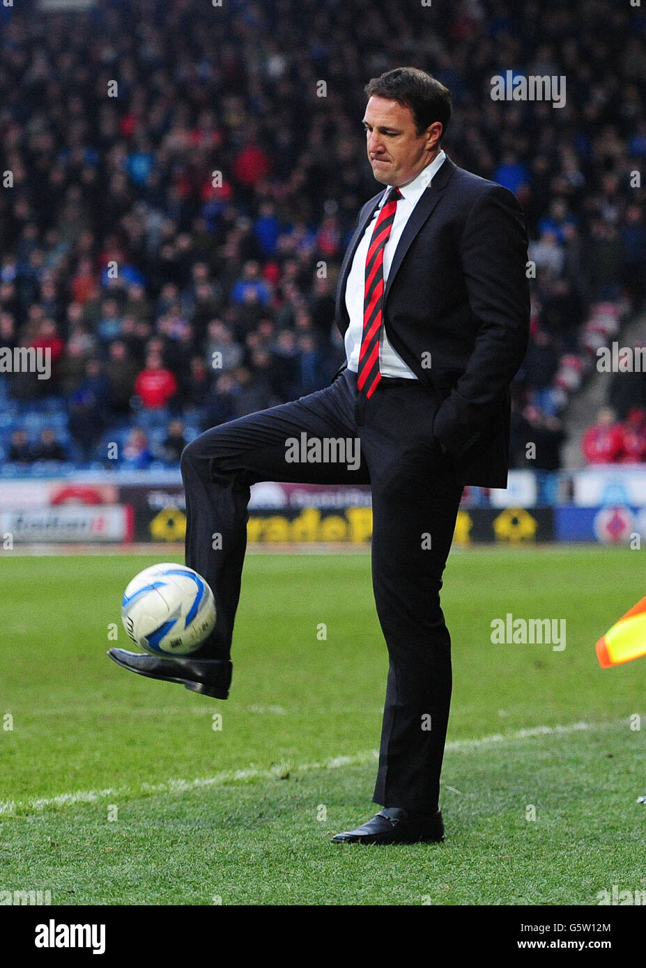 Cardiff City manager Malky Mackay kicks the ball on the touchline during the npower Football League Championship match at John Smith's Stadium, Huddersfield. Stock Photo
