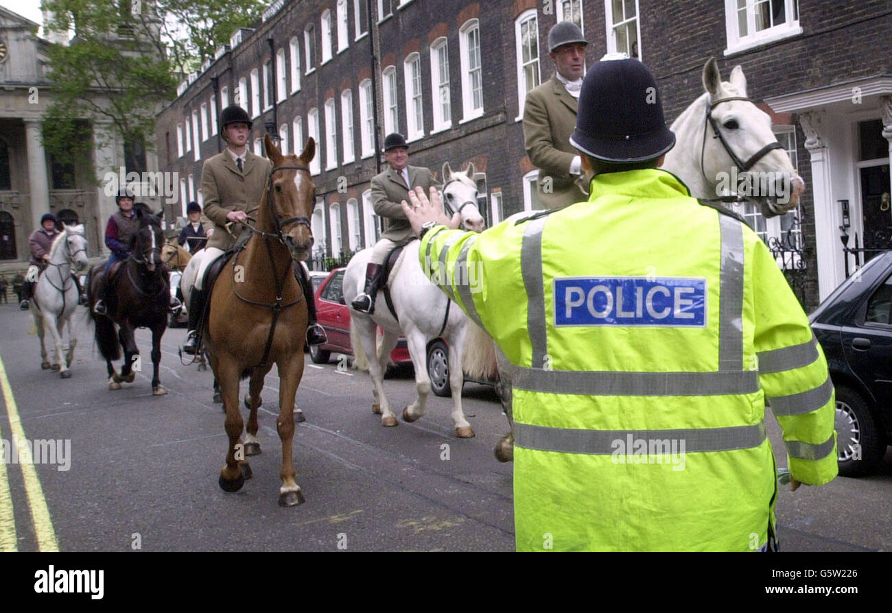 A policeman tries to stop rural workers from all over Britain move down Whitehall towards Downing Street, London, with their dogs and horses to step-up their opposition to any Government move to ban hunting. * The protest is by the Union of Country Sports Workers and is part of the Countryside Alliance's Summer of Discontent. Stock Photo