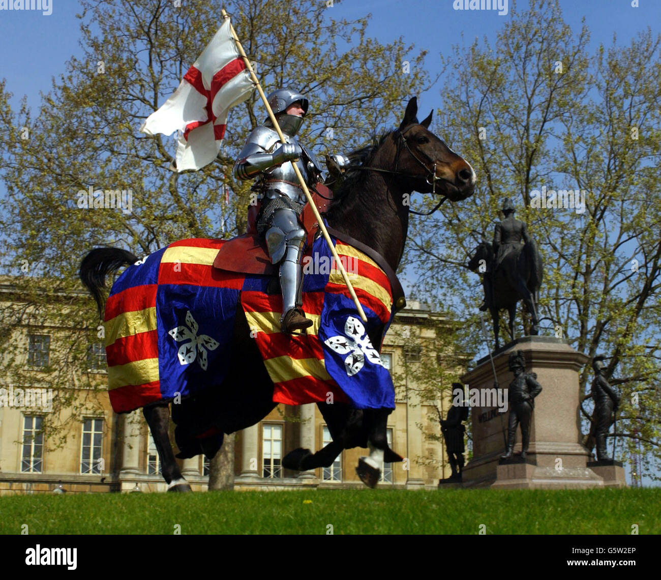 A 'Mediaeval Knight', alias Dominic Sewell, 34, from Peterborough, riding Tequila, flies the St Georges flag across London's Hyde Park Corner on St Georges Day, and to promote the launch of ticket sales for English Heritage's forthcoming History In Action festival. * Which is to be held at Kirby Hall, Northamptonshire on the 10th and 11th August. PA Photo: Fiona Hanson Stock Photo