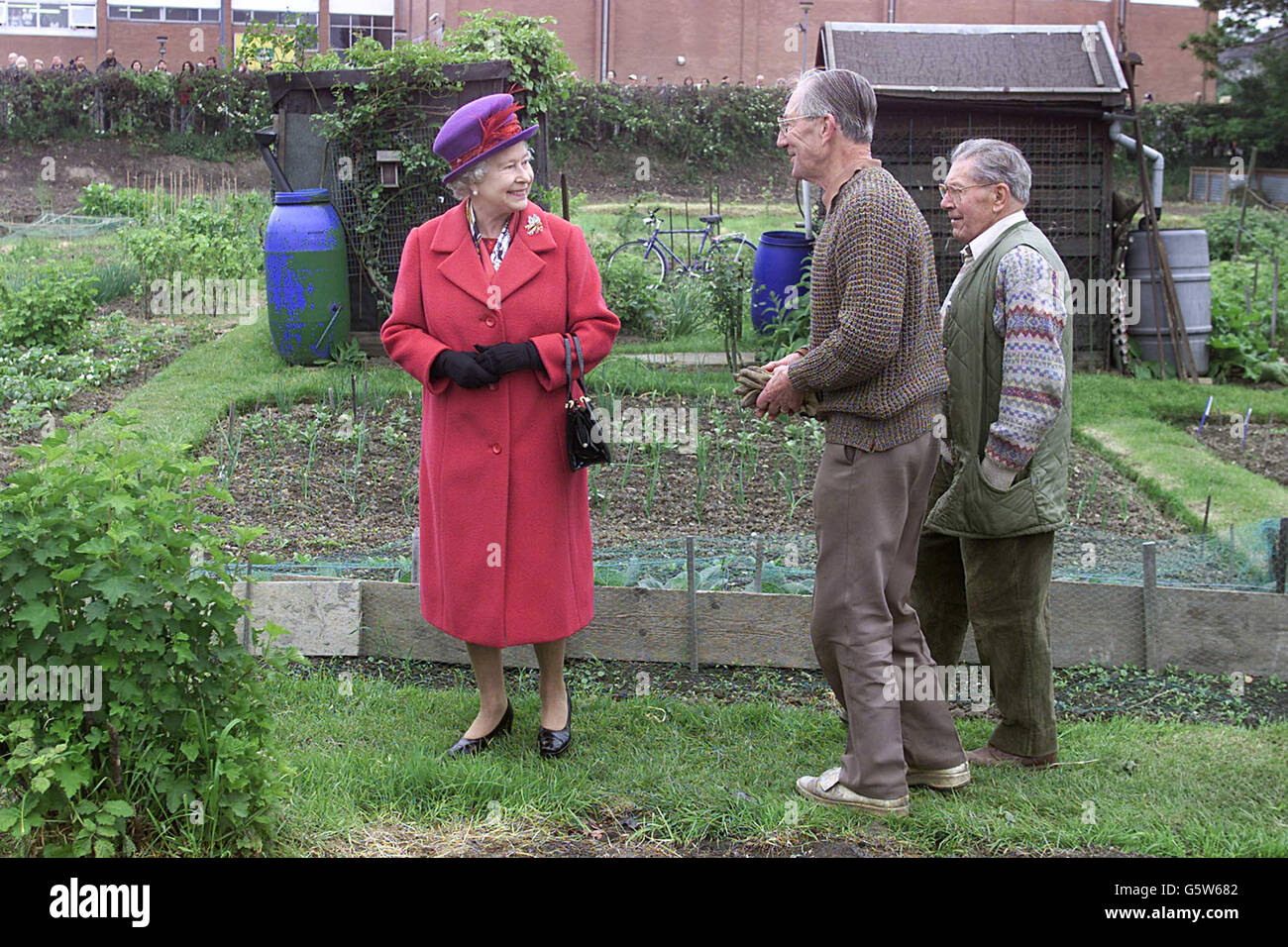 Queen Elizabeth II talks to gardening enthusiasts Donald Doody (right) and John Harrison on their allotment in Redbridge Lane West, during her Golden Jubilee visit to East London. 07/08/02 : Queen Elizabeth II talking to gardening enthusiasts Donald Doody (right) and John Harrison on their allotment in Redbridge Lane West, during her Golden Jubilee visit to East London. According to a 'factfile' released by Buckingham Palace during her Jubilee year the Queen was given hampers of locally produced in Cornwall, Somerset, Suffolk and Powys. Stock Photo