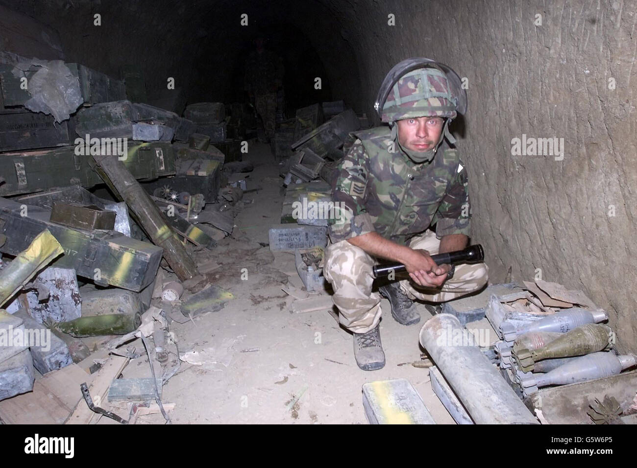 A British Royal Marine at one of the caves in Afghanistan, where they found what their commander, Brigadier Richard Lane, described as a large weapons cache during their part in Operation Snipe. The entrances to the four caves are blocked by metal doors. *... and they are about six to seven feet wide and high. Stock Photo