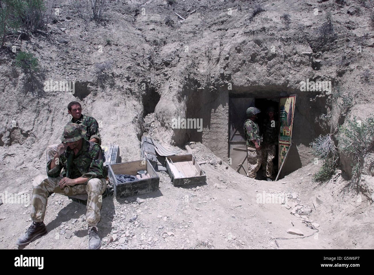 British Royal Marines at one of the caves in Afghanistan, where they found what their commander, Brigadier Richard Lane, described as a large weapons cache during their part in Operation Snipe. The entrances to the four caves are blocked by metal doors. *.... and they are about six to seven feet wide and high. Stock Photo