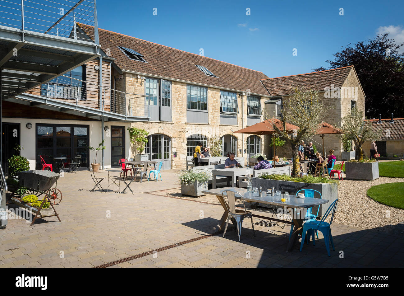 Workers relax over lunch outdoors at the old Glove Factory in Holt UK Stock Photo