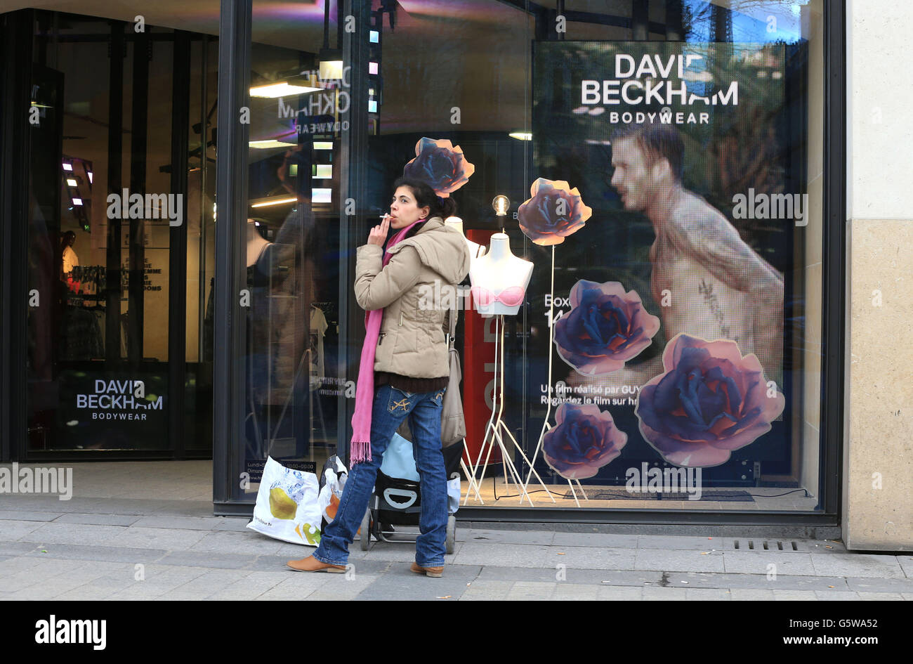 A David Beckham television advert plays in the window of a H&M shop on The Champs-Elysees, Paris opposite the PSG Club shop. Stock Photo