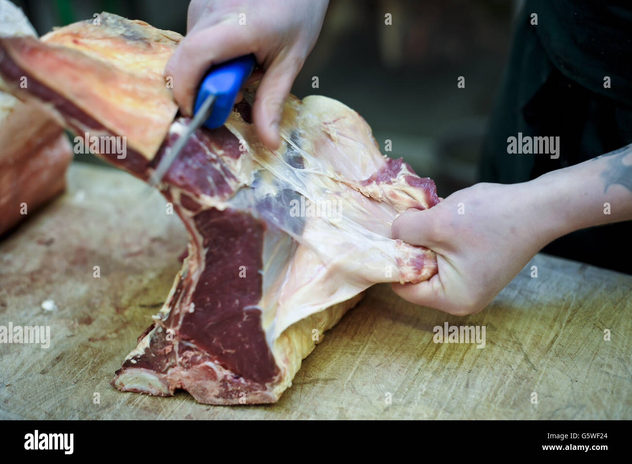 Butcher Paul Gyorgy prepares rib-eye stake at the Sheepdrove Organic Farm shop in Bristol. Stock Photo