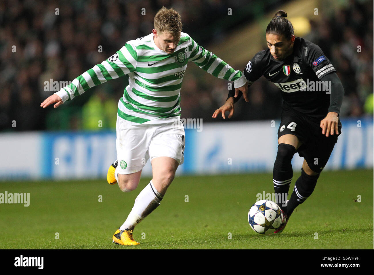 Soccer - UEFA Champions League - Round of Sixteen - First Leg - Celtic v Juventus - Celtic Park. Celtic's Kris Commons (l) and Juventus' Martin Caceres battle for the ball Stock Photo