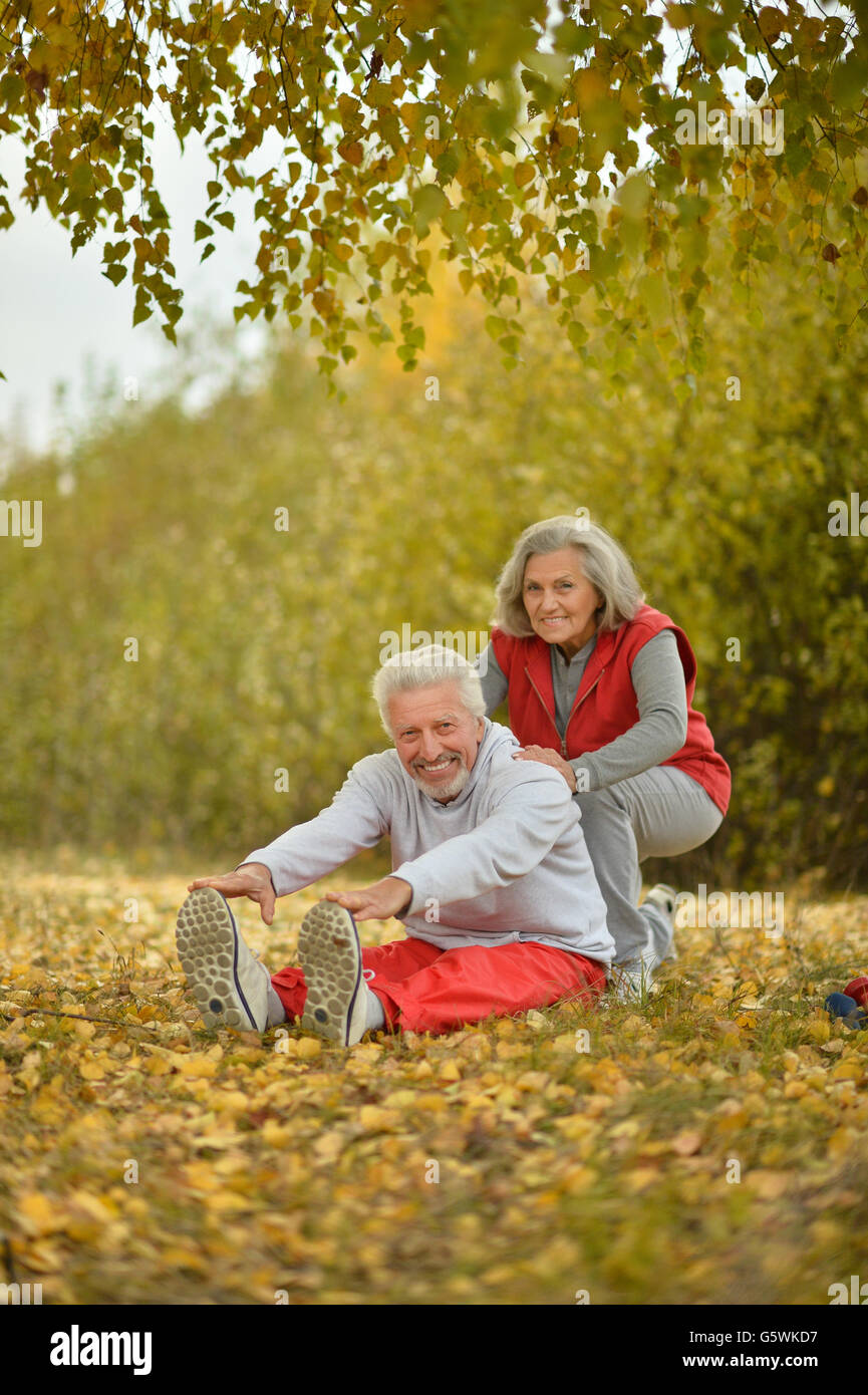 Happy fit senior couple exercising in autumn park Stock Photo - Alamy