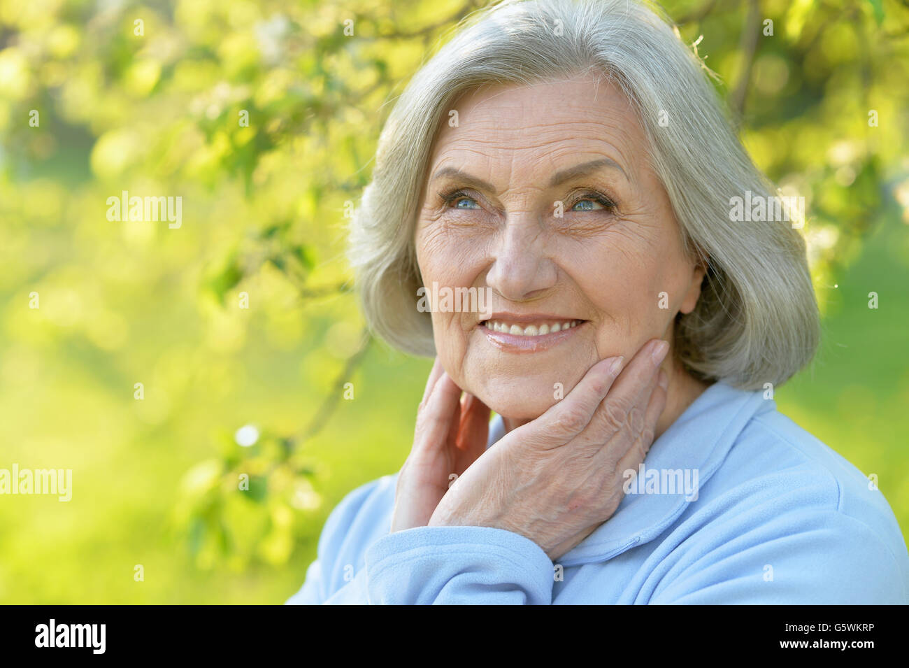Portrait of a beautiful senior woman in green park Stock Photo - Alamy