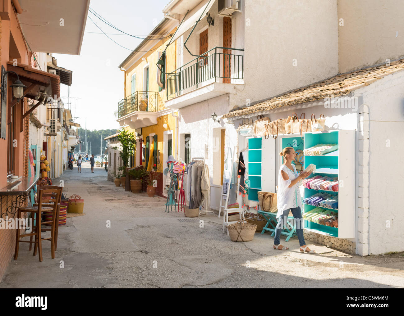 Lakka, Paxos, Greece - young woman setting up her shop (Mare) selling clothing and accessories Stock Photo