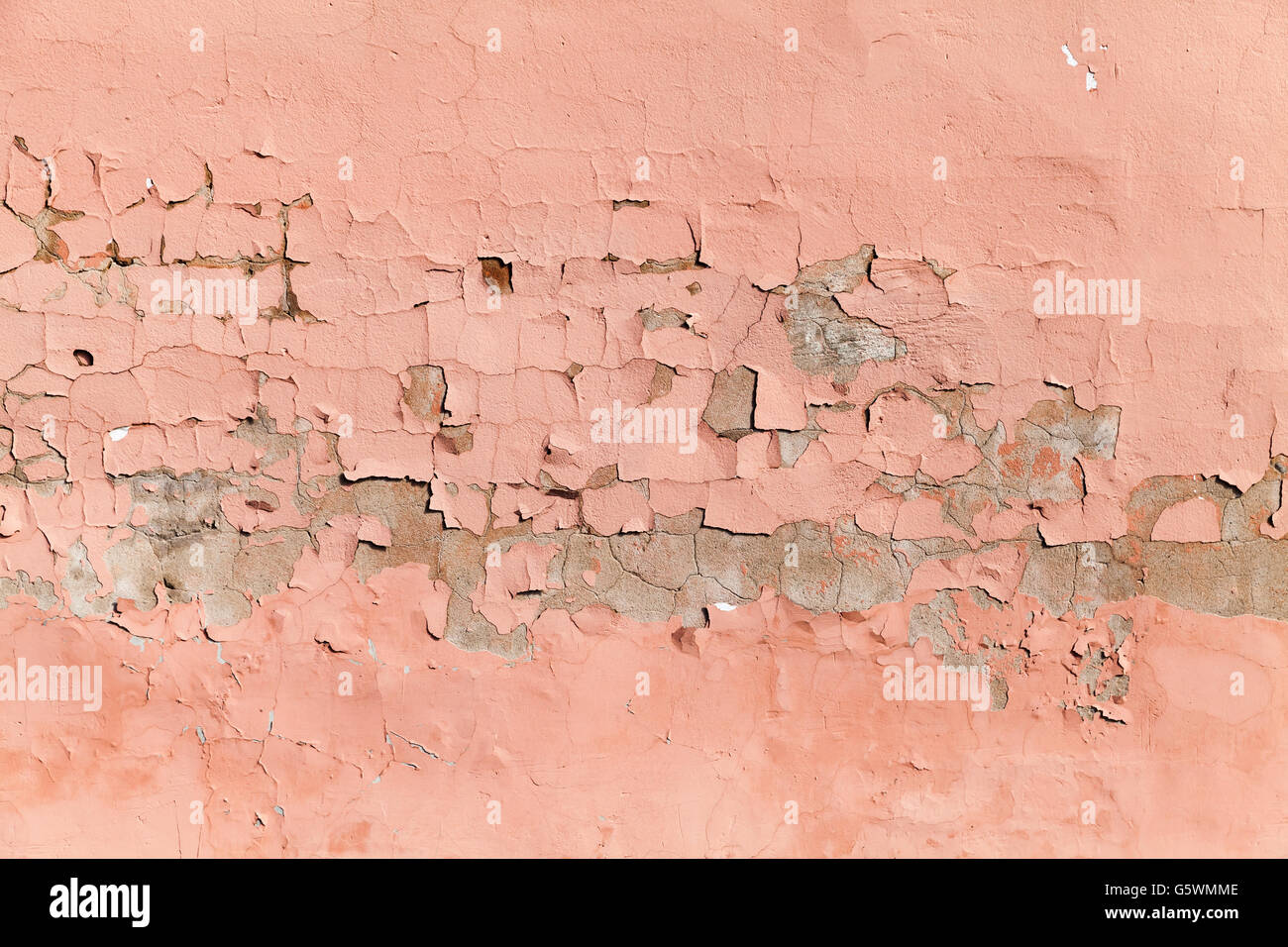 Background texture of an old concrete wall with peeling layer of pink paint Stock Photo