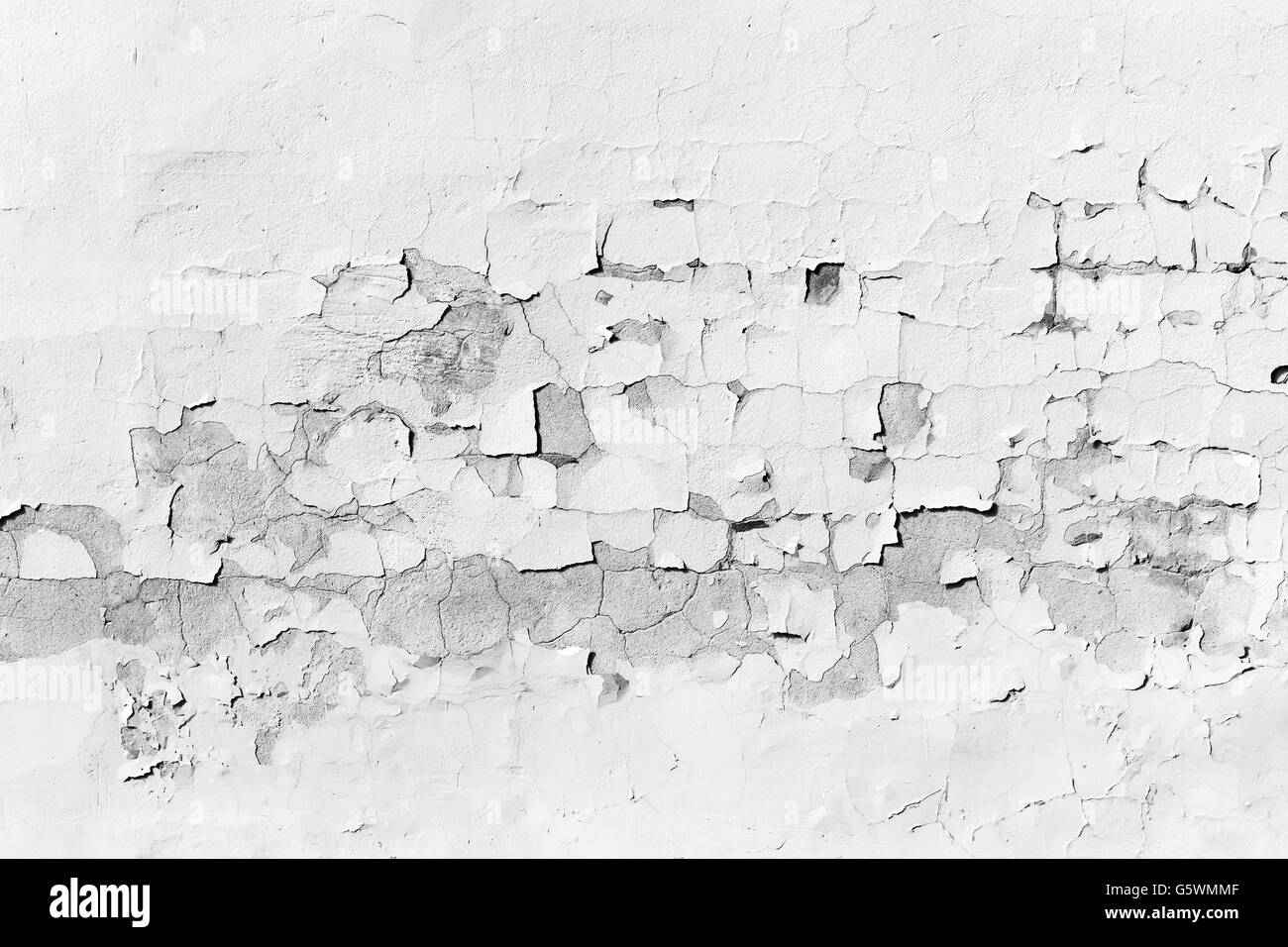 Background texture of old concrete wall with peeling layer of white paint Stock Photo