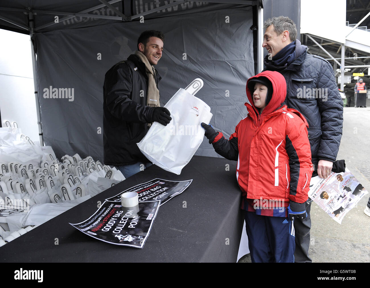 Soccer - Barclays Premier League - Fulham v Stoke City - Craven Cottage. Young Fulham fans receive their foam fingers and goody bags outside the Putney End Stock Photo