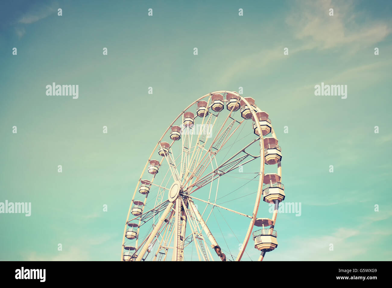 Retro toned picture of a Ferris wheel at sunset. Stock Photo