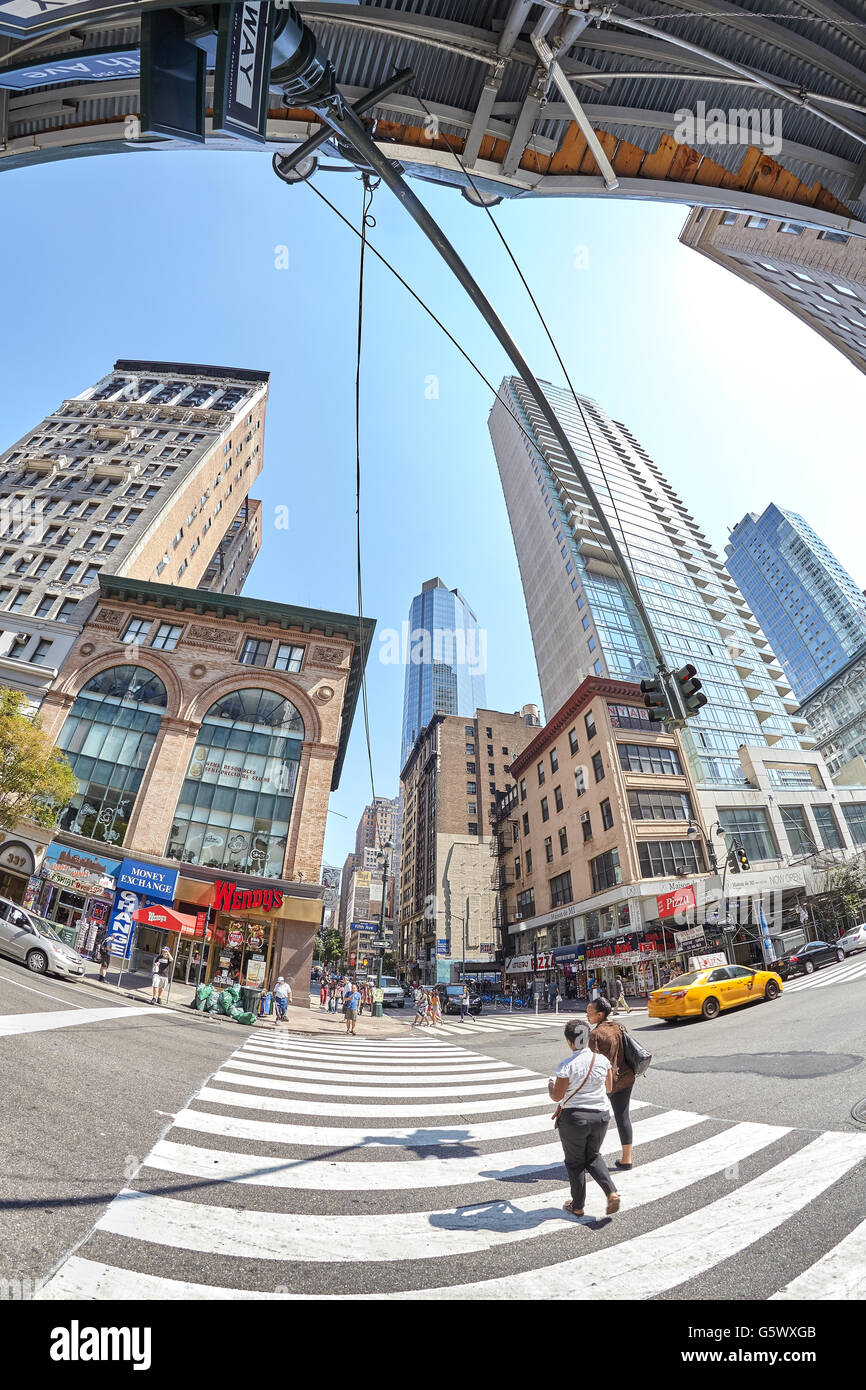 New York, USA - August 15, 2015: Fisheye lens picture of pedestrian crossing at busy Fifth Ave and East 33rd St corner. Stock Photo