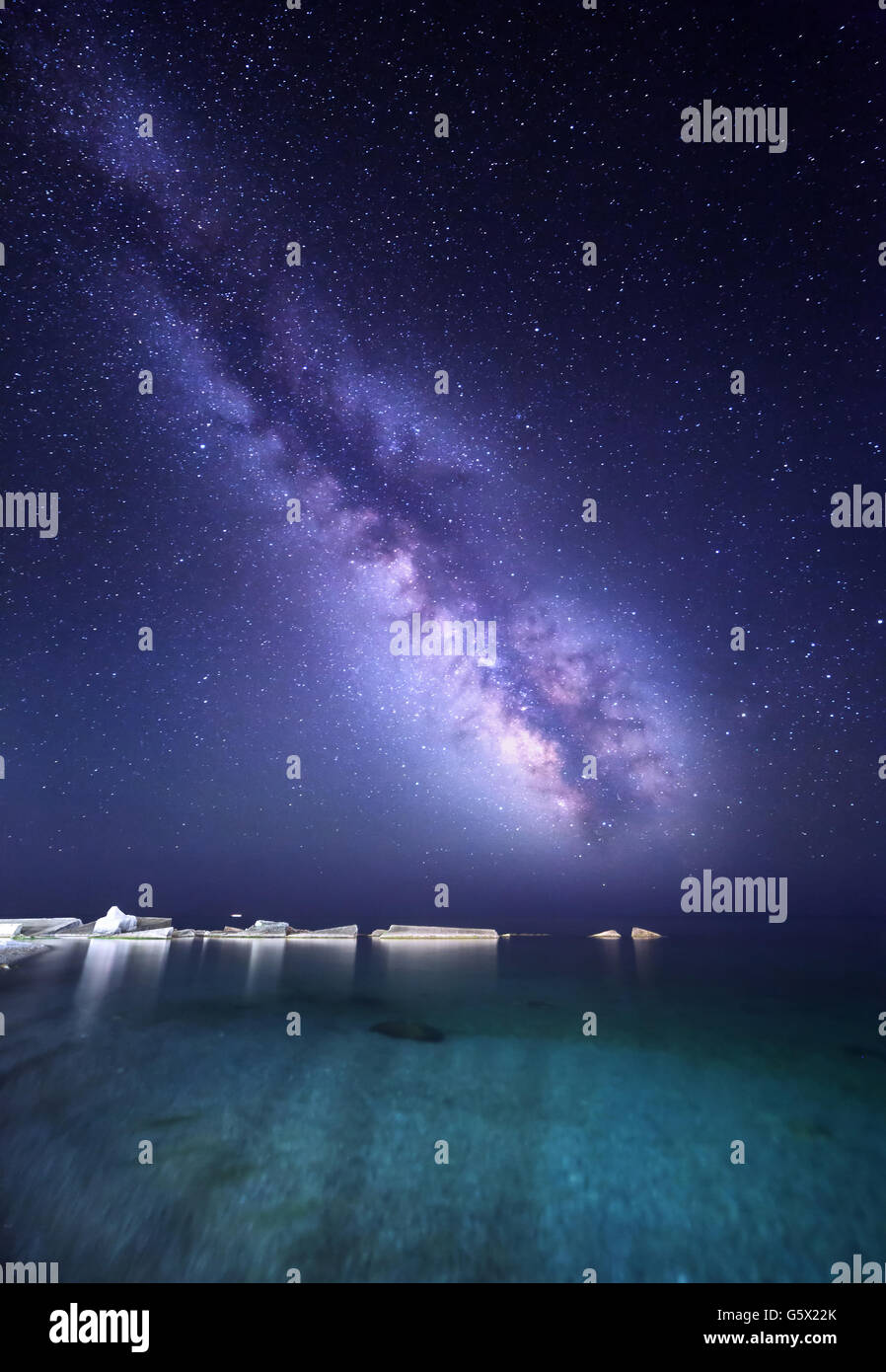 Night landscape with colorful Milky Way at the sea with stones. Starry sky. Space background Stock Photo