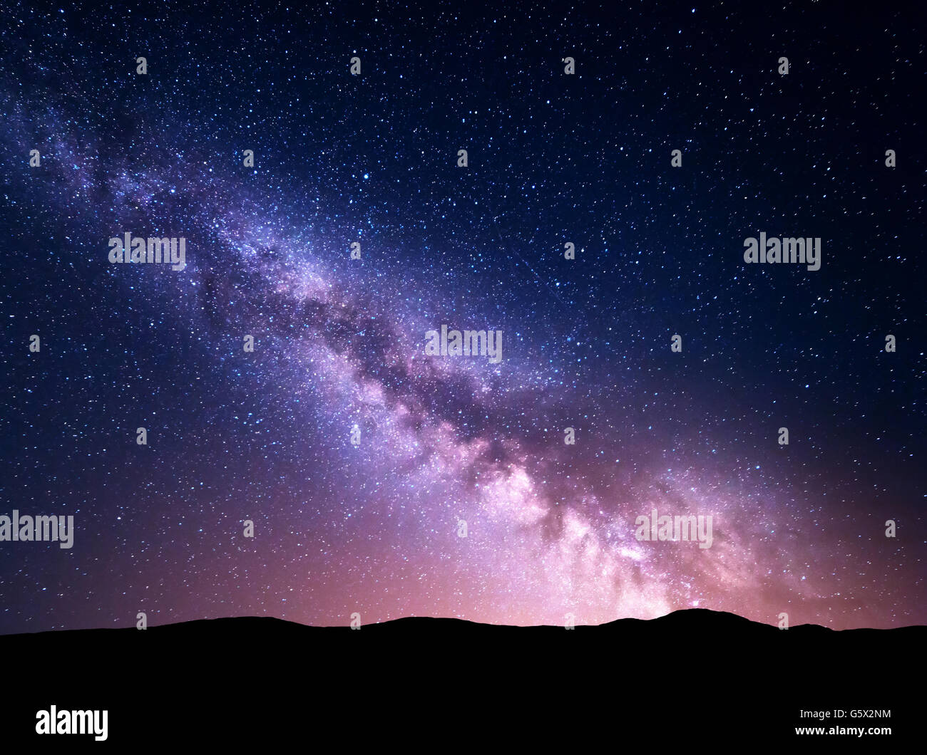 Night landscape with vibrant Milky Way at mountains. Starry sky with hills at summer. Beautiful Universe. Space background. Nigh Stock Photo