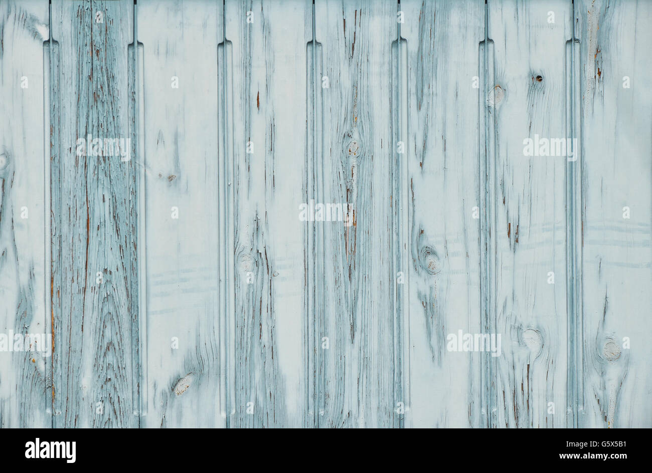 Light blue teal vintage old grunge aged painted wooden panel with vertical planks texture background with paint scaling Stock Photo