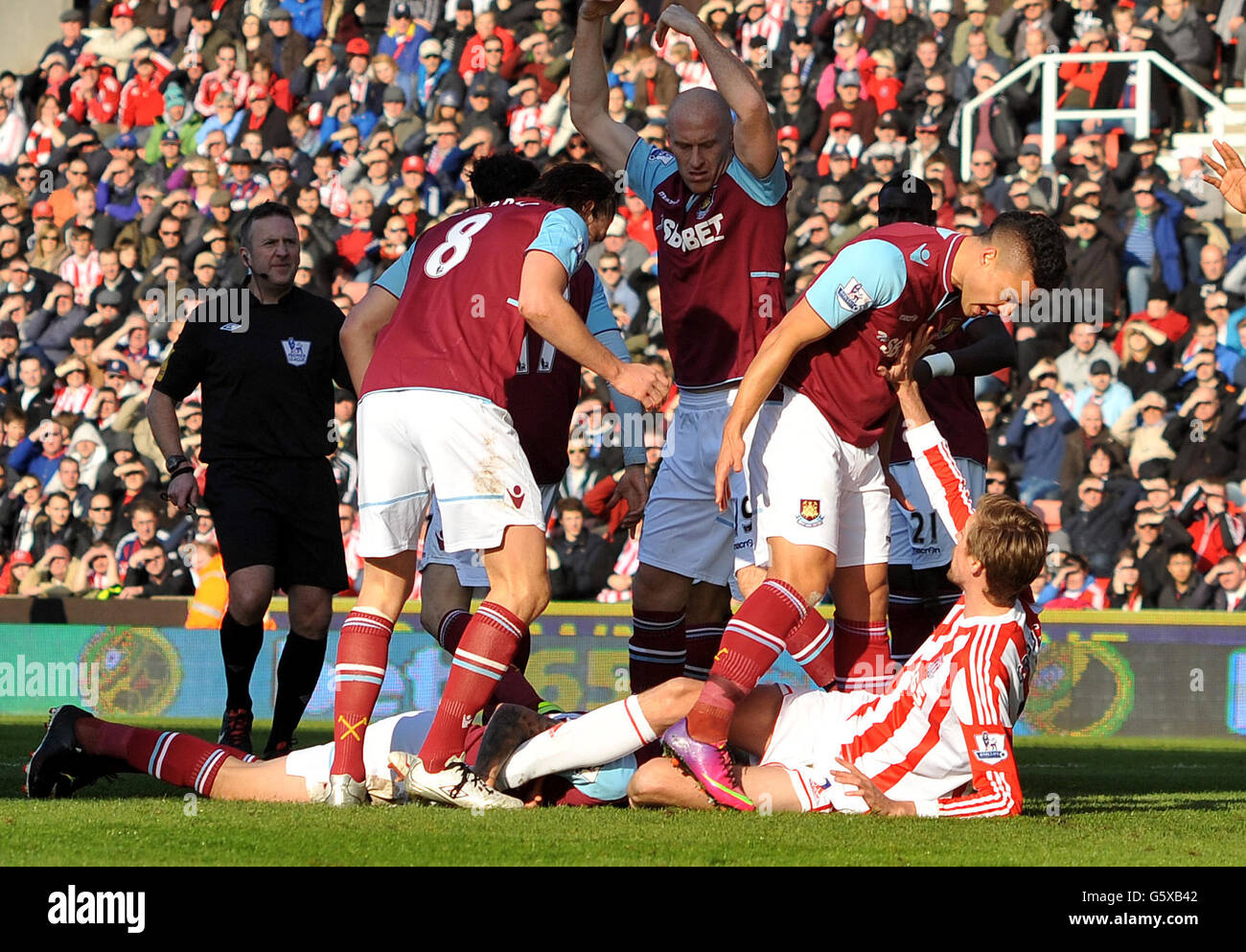 West Ham United's Winston Reid challenges Stoke City's Peter Crouch after a foul by Peter Crouch on Matthew Taylorduring the Barclays Premier League match at the Britannia Stadium, Stoke. Stock Photo