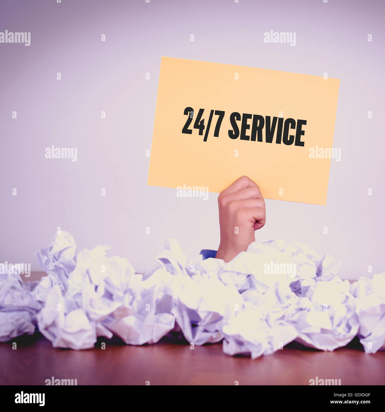 HAND HOLDING YELLOW PAPER WITH 24/7 SERVICECONCEPT Stock Photo