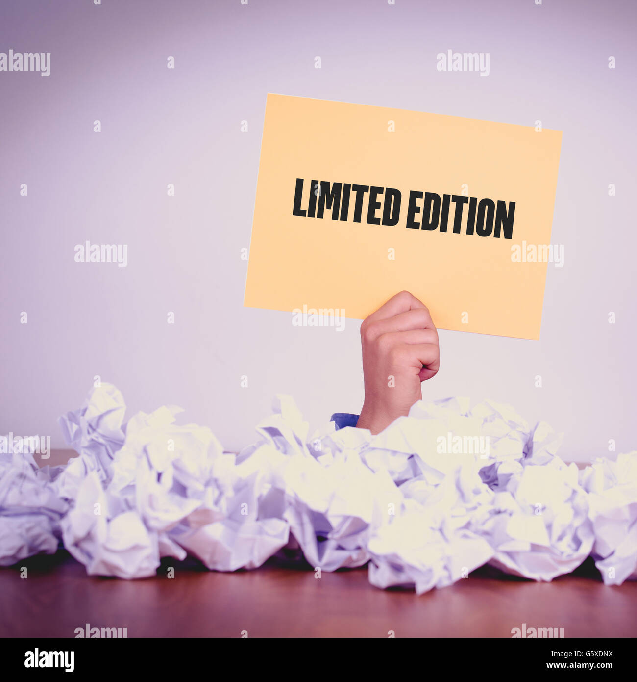 HAND HOLDING YELLOW PAPER WITH LIMITED EDITIONCONCEPT Stock Photo