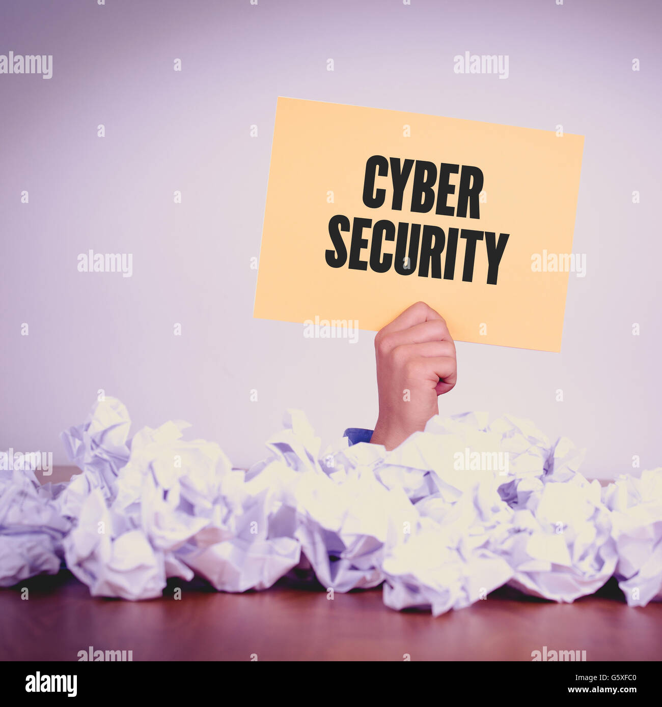 HAND HOLDING YELLOW PAPER WITH CYBER SECURITYCONCEPT Stock Photo